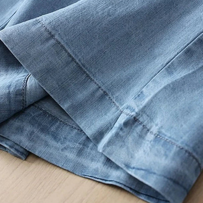 Folded blue denim fabric on a cardboard surface