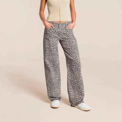 Person wearing leopard print pants on a beige background