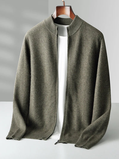 Green sweater on a hanger against a gray background