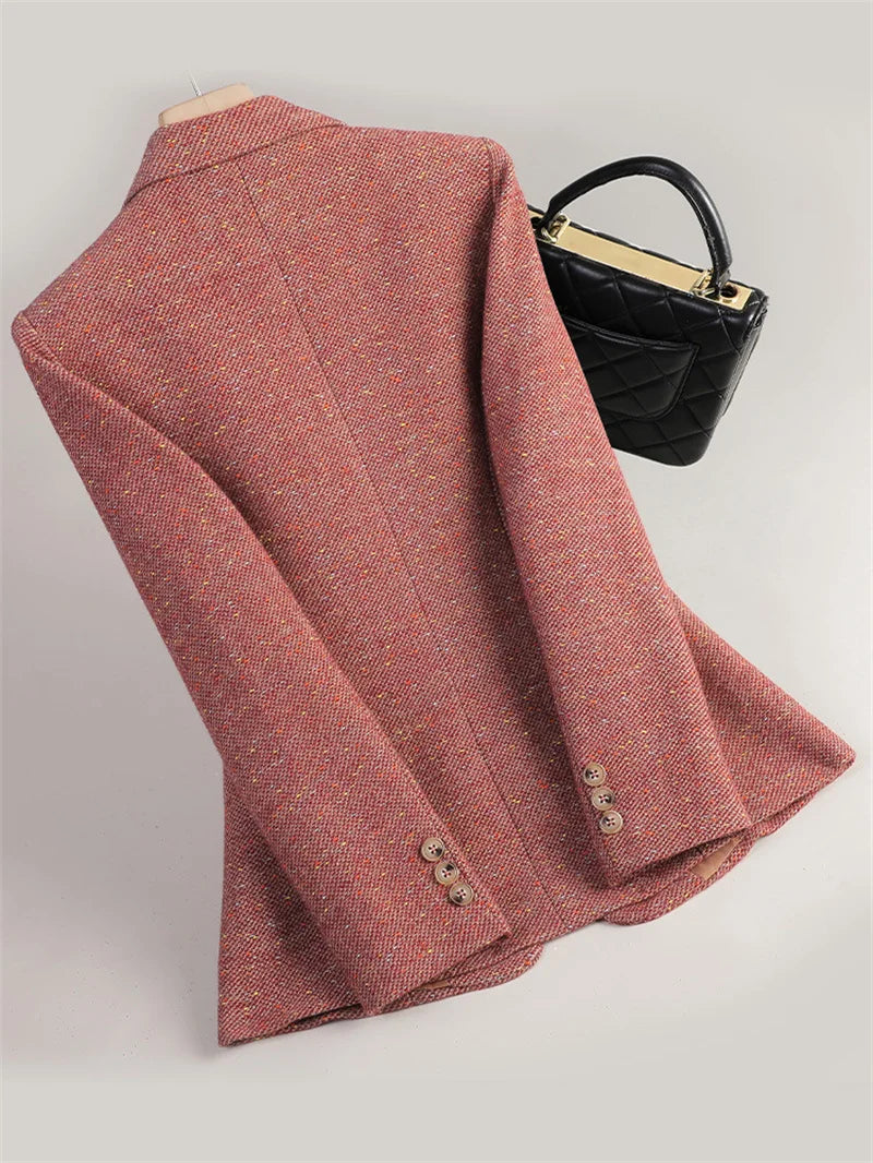 Folded red blazer with a black handbag on a light gray background