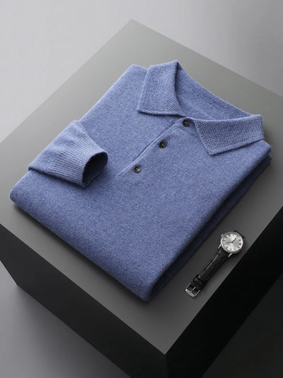 Folded blue polo shirt on a dark surface with a watch beside it