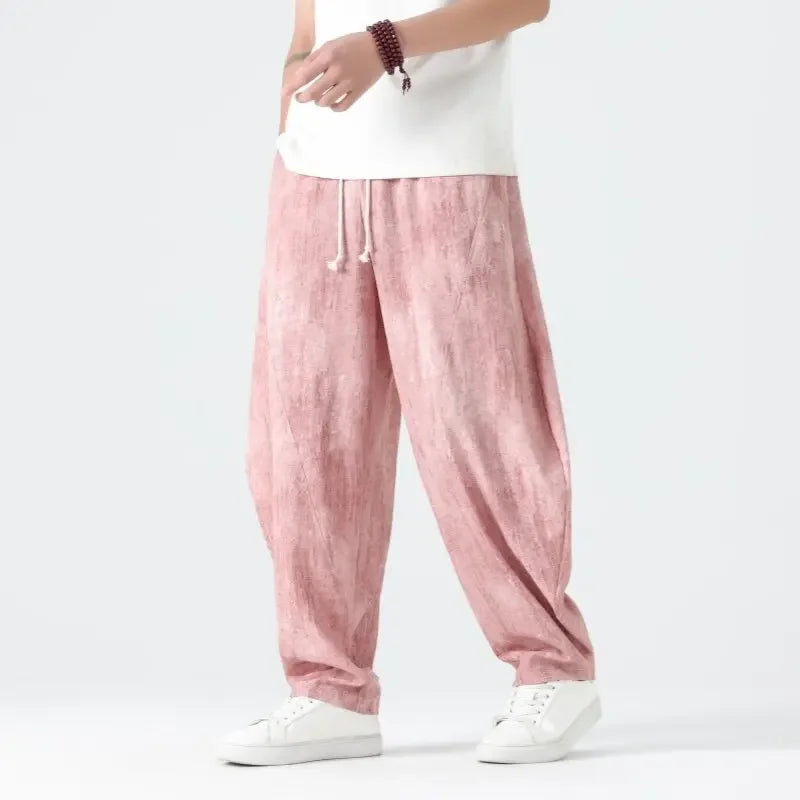 Person wearing pink pants and white shoes on a plain background