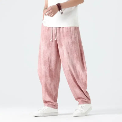 Person wearing pink pants and white shoes on a plain background
