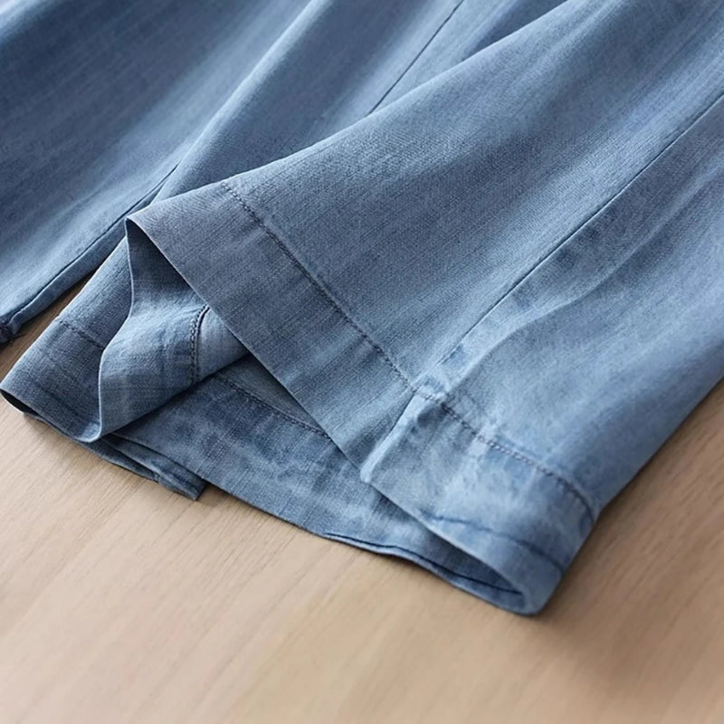 Folded blue denim fabric on a wooden surface