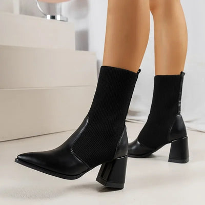 Black sock boots worn with a neutral background