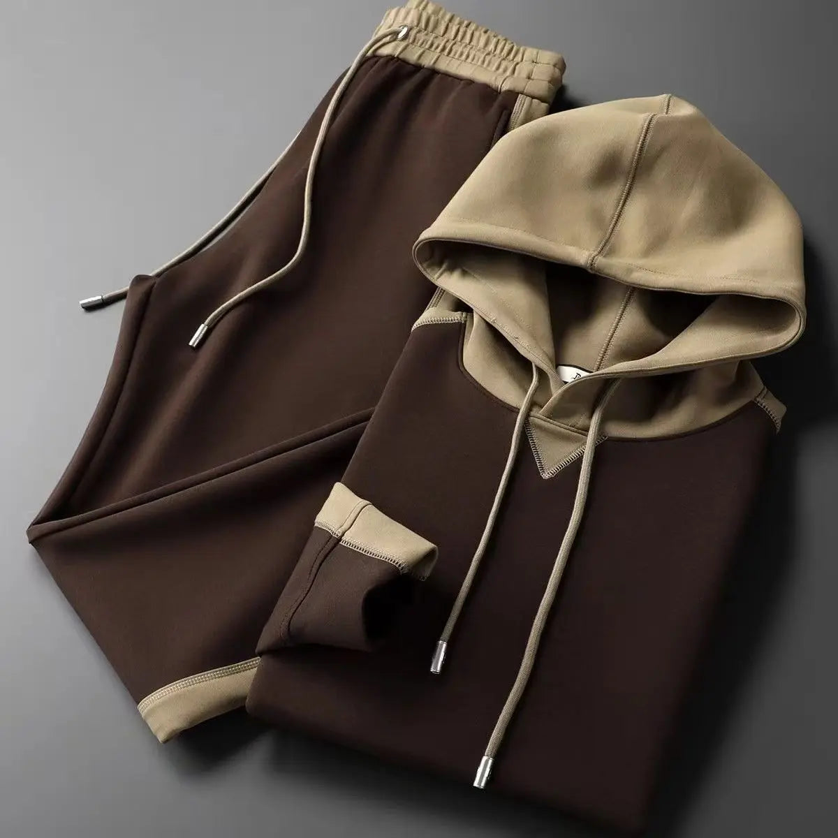 Brown hoodie and pants set on a gray background