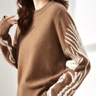 Brown sweater with white pattern on sleeves against a neutral background