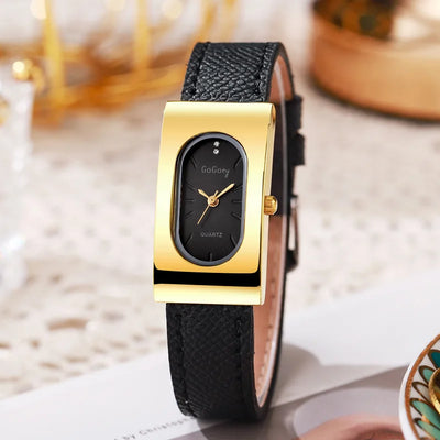 Gold and black watch with leather strap on a light surface