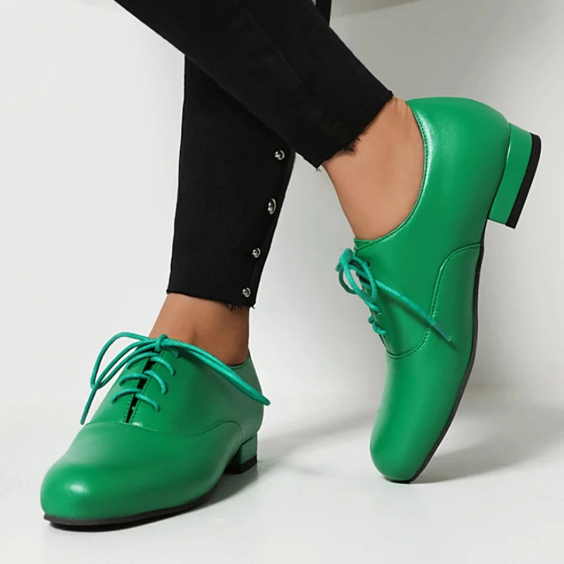 Green shoes worn with black pants on a white background