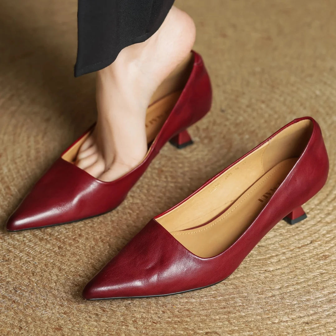 Red high-heeled shoes on a textured surface