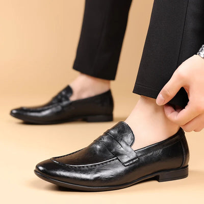 Person wearing black leather shoes on a beige background
