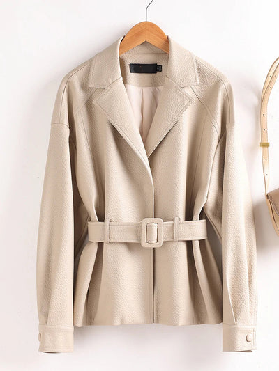 Beige trench coat with a belt on a wooden hanger against a white background