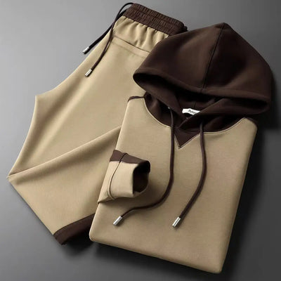 Folded beige hoodie with brown accents on a gray background