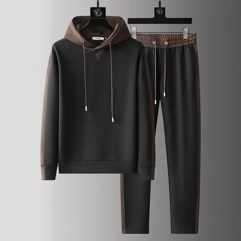 Black hoodie and pants set with brown accents on hangers against a gray background