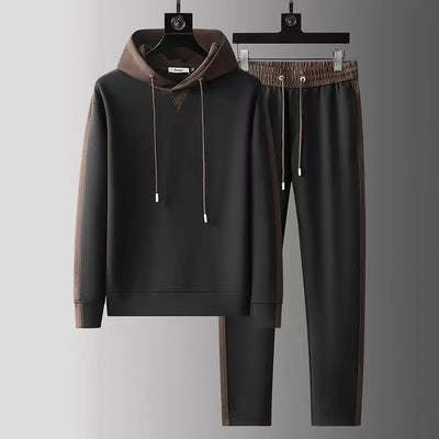 Black hoodie and pants set with brown accents on hangers against a gray background