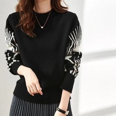 Black sweater with zebra pattern sleeves worn by a person on a plain background