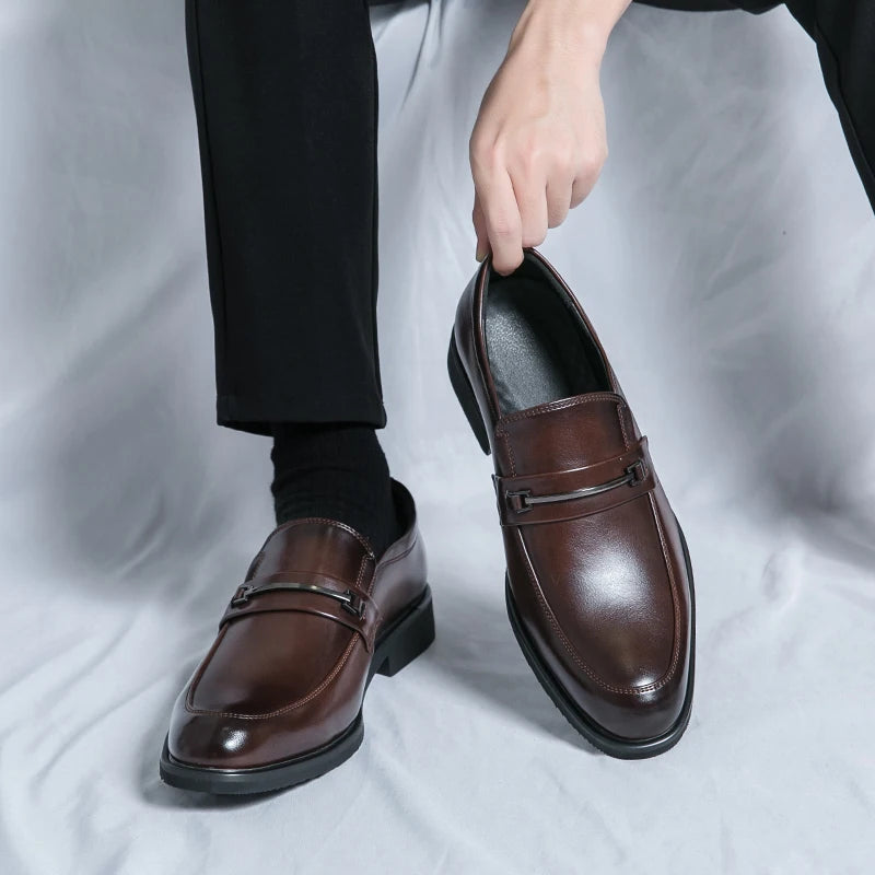 Brown dress shoes being worn with black socks on a light gray background