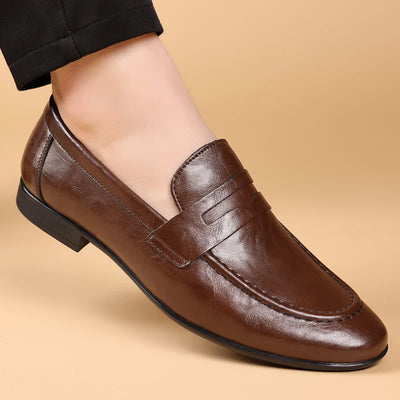 Brown leather loafer shoe on a beige background