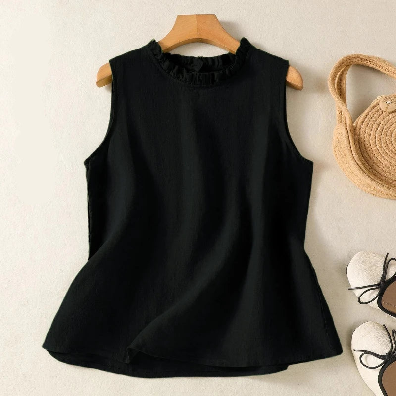 Black sleeveless top on a wooden hanger with a textured beige background