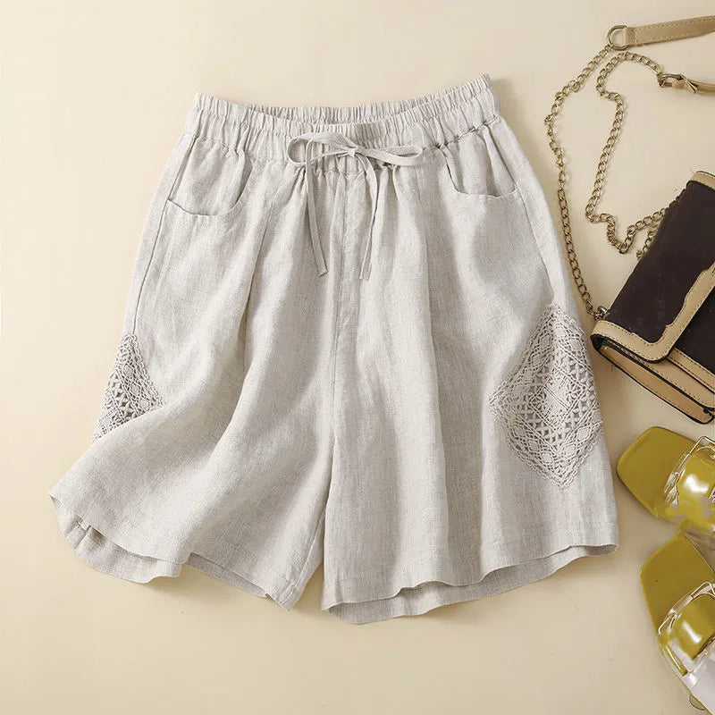Light gray shorts with lace detailing on a beige background