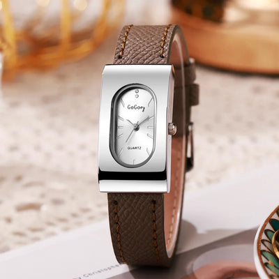 Watch with brown leather strap and silver case on a blurred background