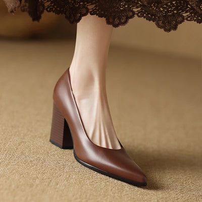 Brown high-heeled shoe worn with a lace skirt on a beige background
