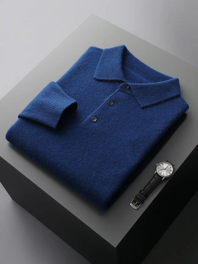 Folded blue polo shirt with a watch on a gray surface