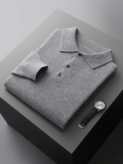 Folded gray polo shirt with a watch on a dark surface