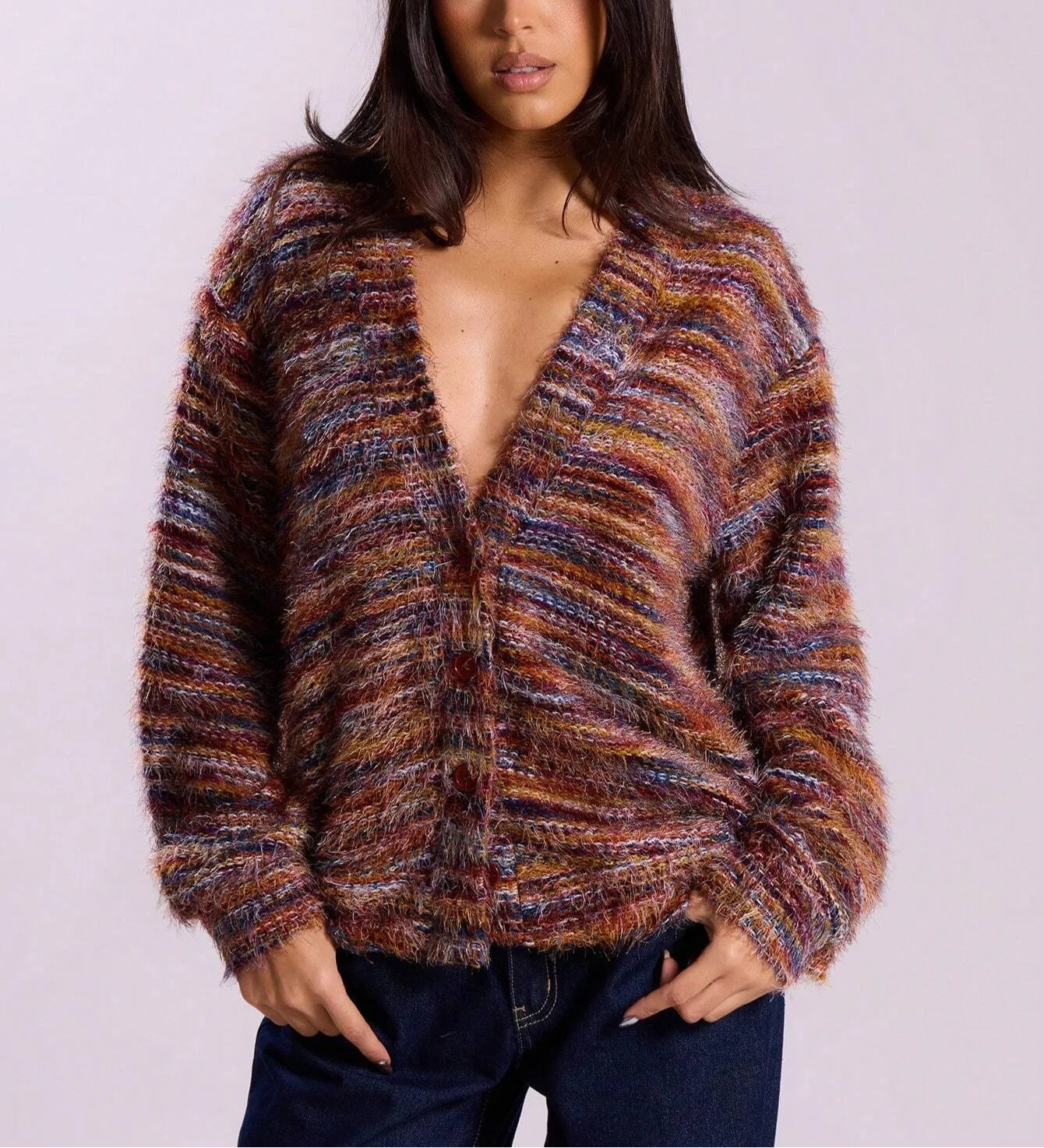 Woman wearing a colorful knitted cardigan against a plain background