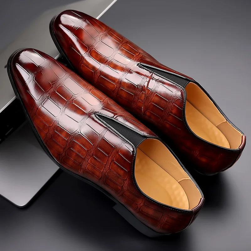 Pair of brown leather loafers with a textured finish on a dark background