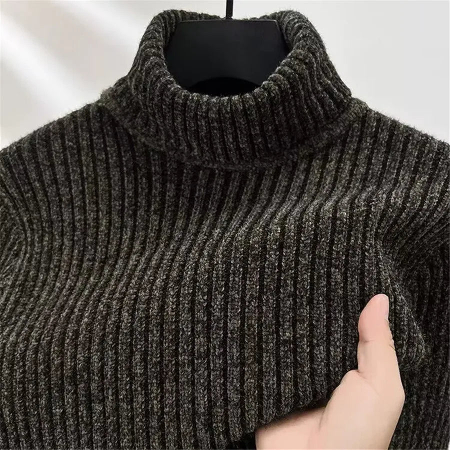 Dark ribbed sweater on a hanger with a hand holding it