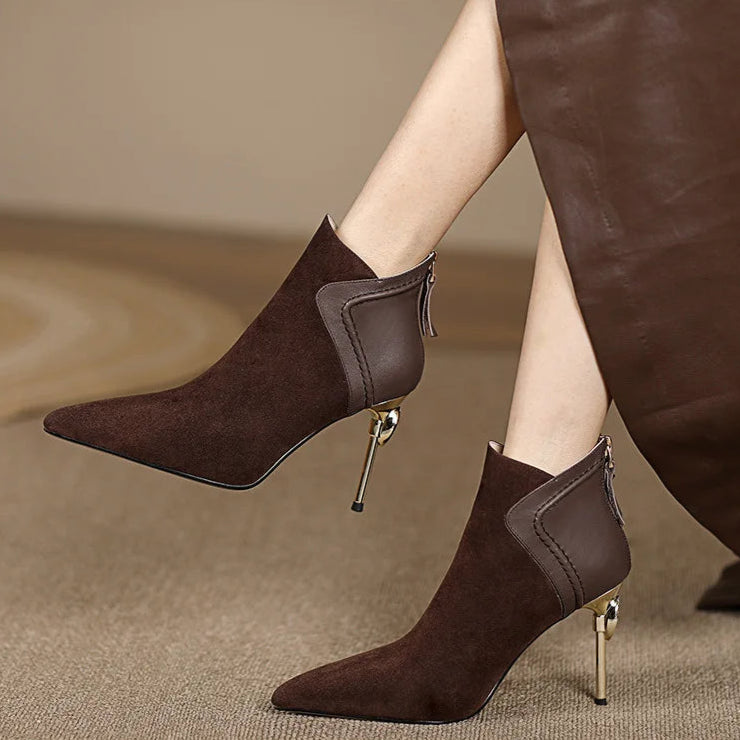 Brown high-heeled ankle boots worn by a person on a beige background