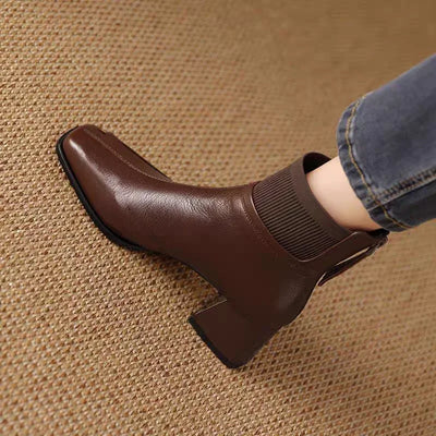 Brown ankle boot worn on a textured brown surface
