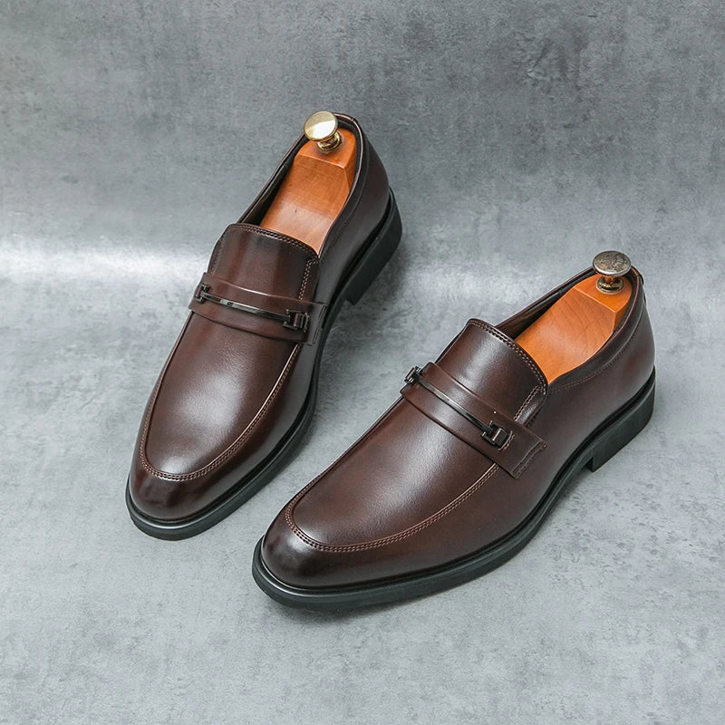Pair of brown leather loafers on a gray concrete surface