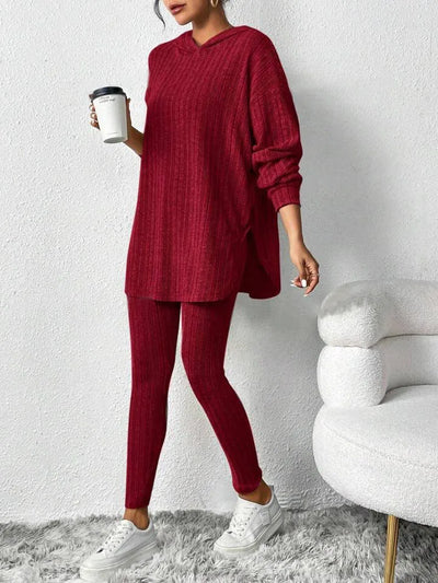 Person wearing a red knit outfit holding a coffee cup against a white background