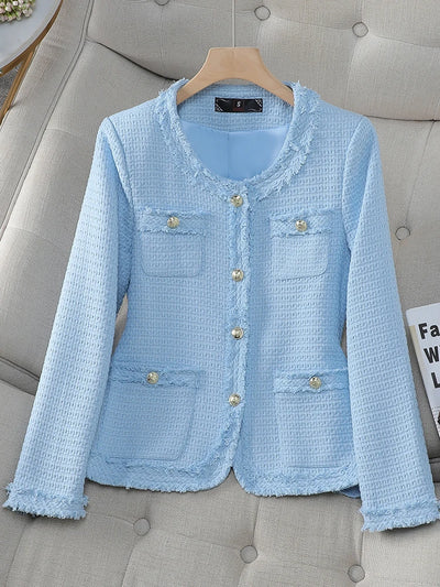 Light blue textured jacket on a hanger against a gray sofa background