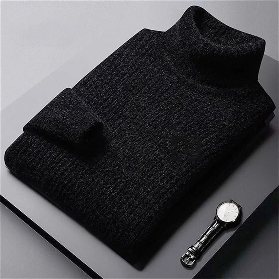 Dark gray sweater on a light gray surface with a watch next to it