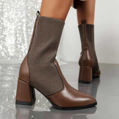 Brown sock boots with block heels on a reflective surface