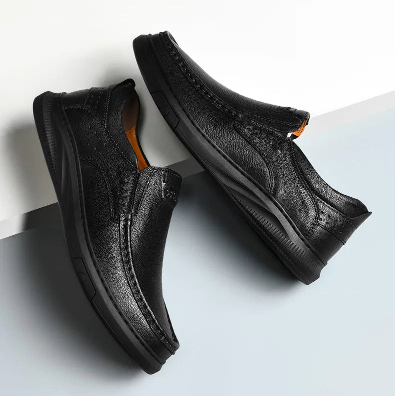 Pair of black leather shoes on a light gray background