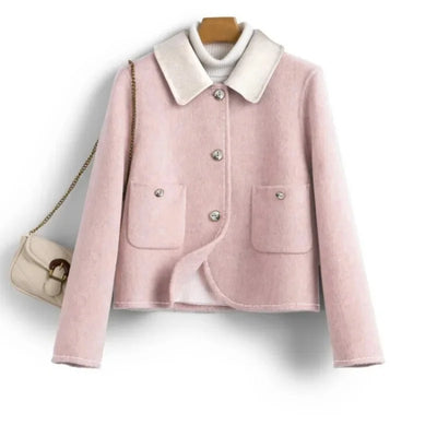 Pink jacket with white collar on a hanger against a white background