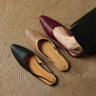 Three flat shoes in black, brown, and red on a textured surface