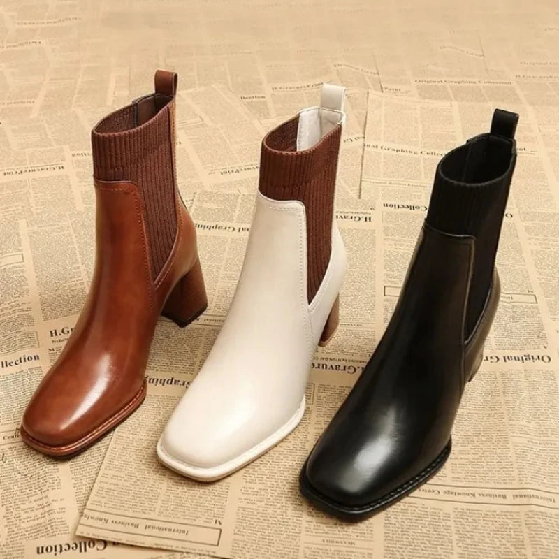 Three pairs of boots (brown, white, black) on a newspaper background