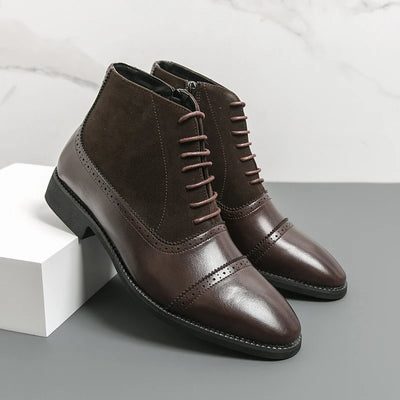 Pair of brown leather boots on a gray surface with a white background