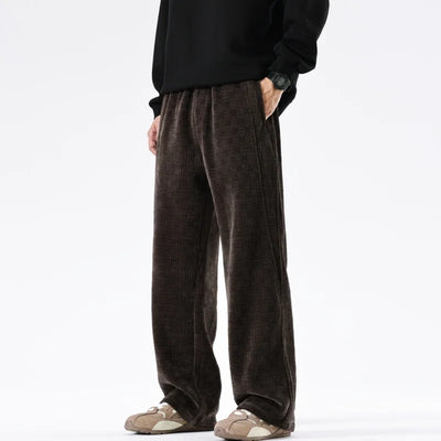 Person wearing brown pants and a black top on a white background