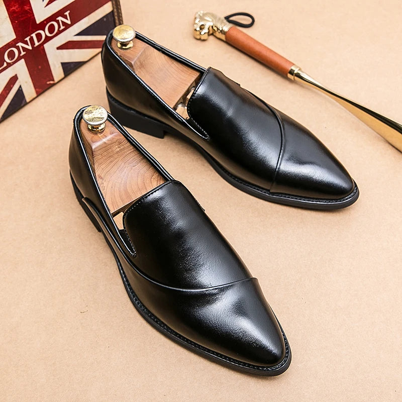 Black leather shoes on a beige surface with a British flag in the background