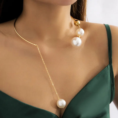 Pearl necklace and earrings on a person wearing a green dress