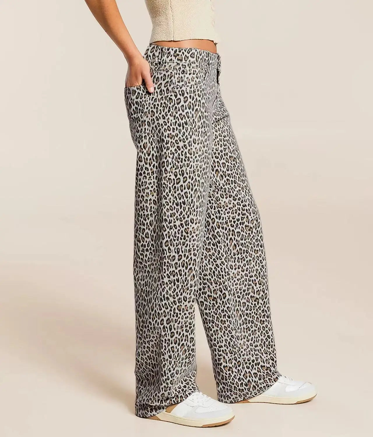 Leopard print pants worn by a person on a beige background