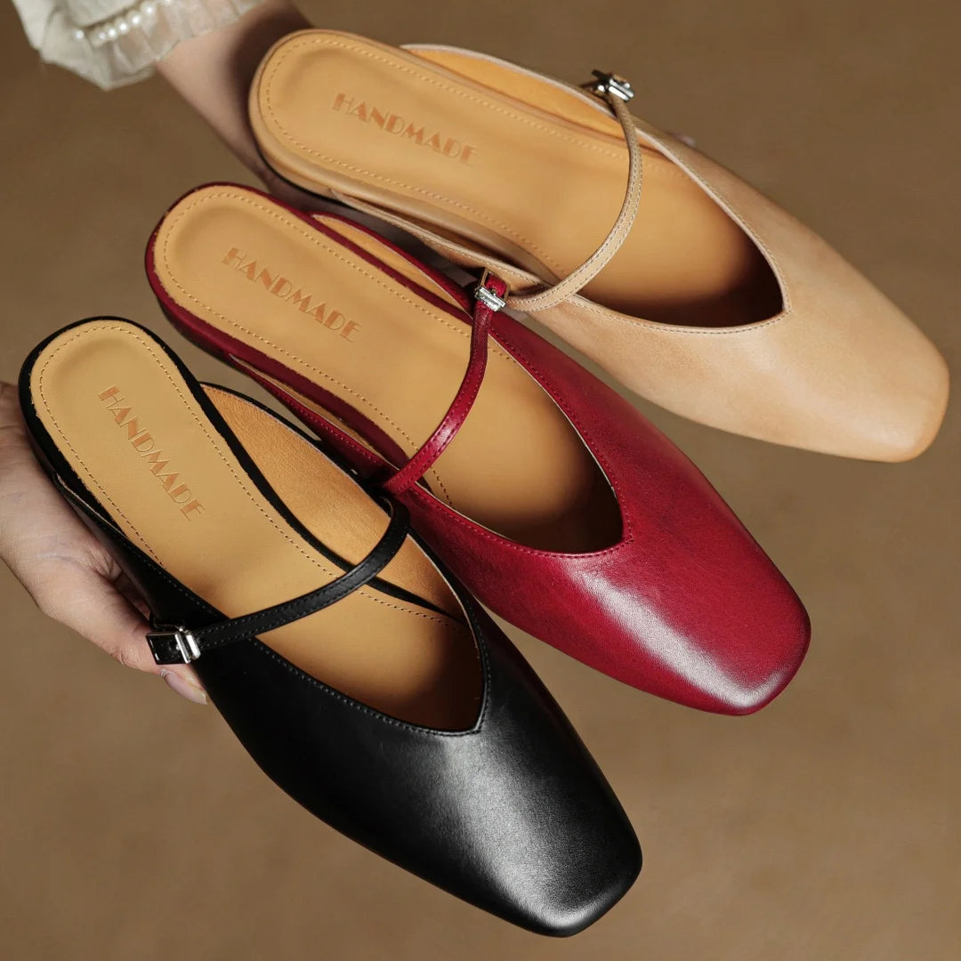 Three pairs of flat shoes in black, red, and beige on a brown background.