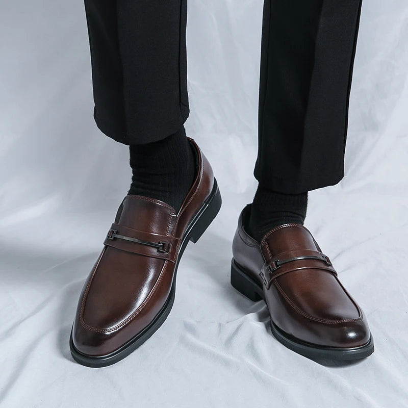Brown dress shoes worn with black pants on a white background