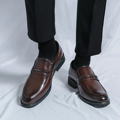 Brown dress shoes worn with black pants on a white background